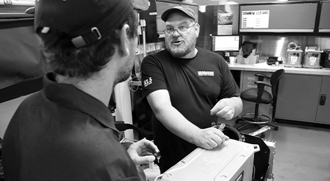 Two engineers in a product laboratory talk to each other over a Vanguard battery pack.
