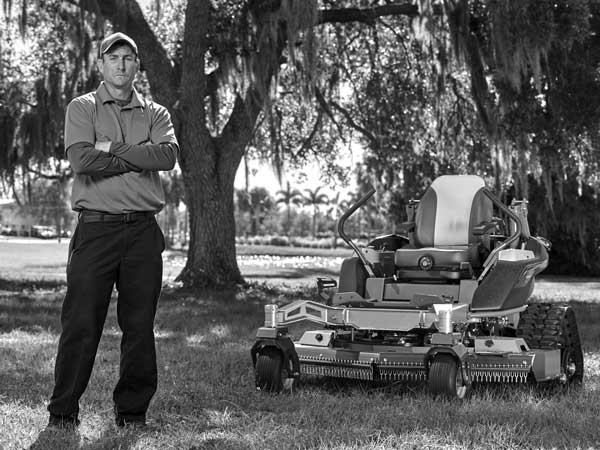 Landscaper standing next to turf equipment powered by Vanguard